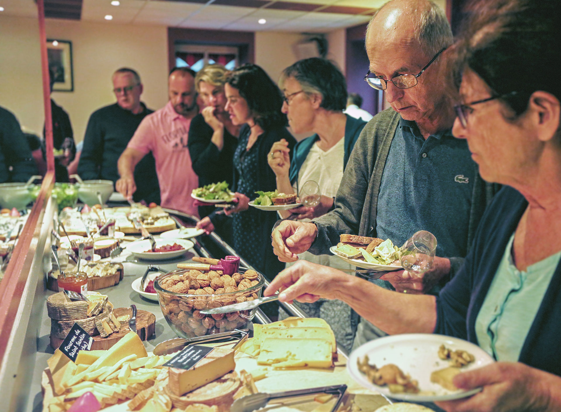 Groupe de personnes se servant au buffet de fromages du restaurant de groupes Les Tablées de L'Oustal