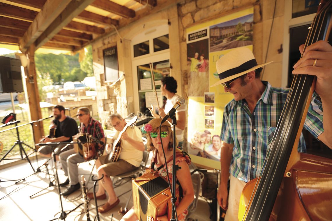Groupe de musiciens en train de jouer pour un concert apéro au bar de L'Oustal à Pont-les-Bains en Aveyron
